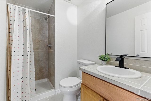 bathroom featuring tile patterned floors, a stall shower, toilet, and vanity