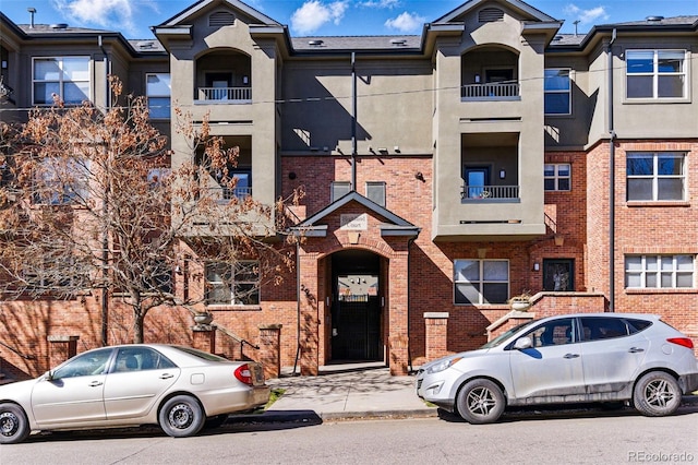 view of property featuring stucco siding and brick siding