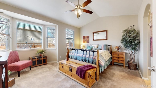 bedroom featuring lofted ceiling, a ceiling fan, arched walkways, baseboards, and light colored carpet