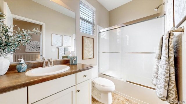 full bath featuring shower / bath combination with glass door, vanity, and toilet