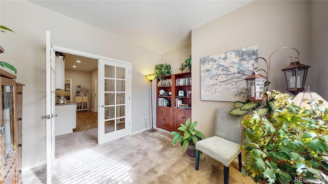 sitting room featuring french doors and carpet floors