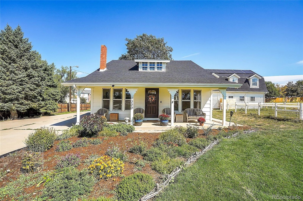 view of front of property featuring covered porch and a front lawn