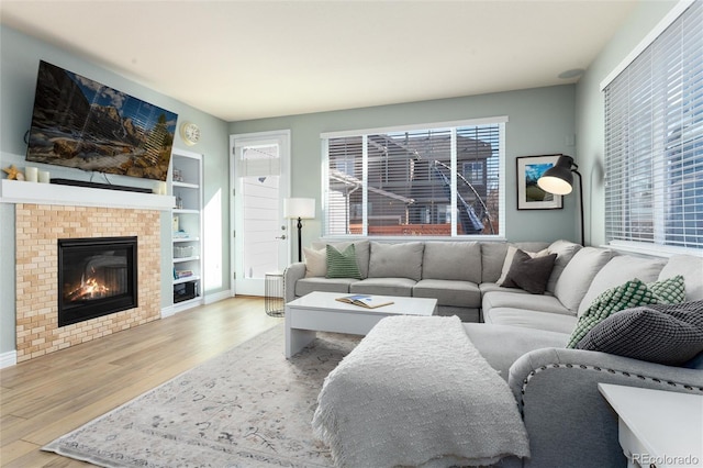 living room with a tile fireplace and wood finished floors