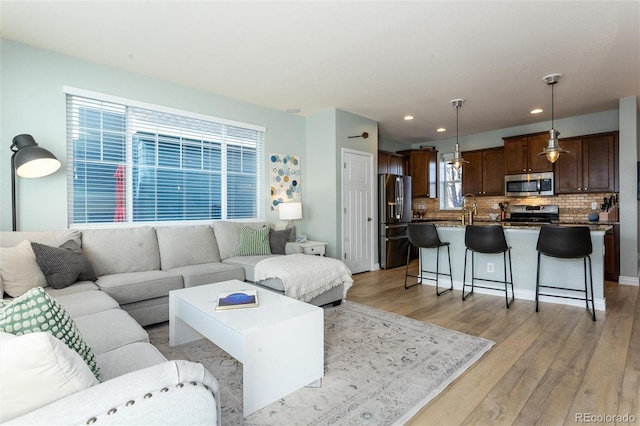 living room with light wood-type flooring and recessed lighting