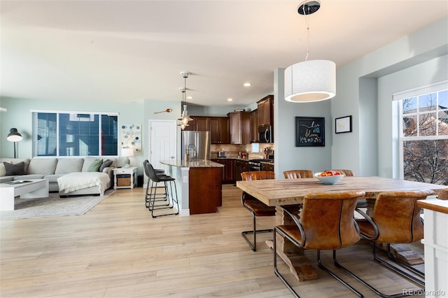 dining space with light wood-style floors and recessed lighting