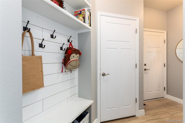 mudroom featuring baseboards and light wood finished floors