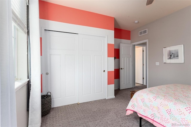 carpeted bedroom featuring a closet and visible vents