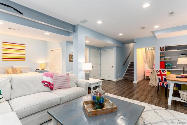 living room with dark wood-style flooring, stairway, visible vents, and recessed lighting