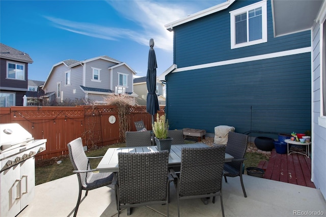 view of patio featuring outdoor dining space, a grill, and fence