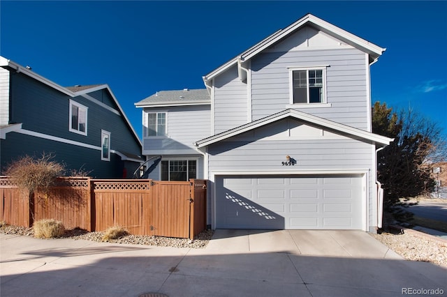 traditional home with a garage, fence, and driveway