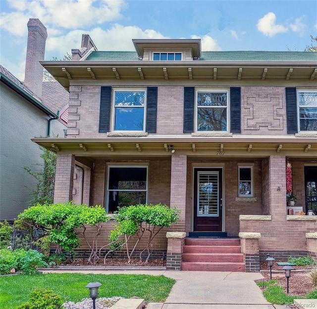 view of front of home with covered porch and brick siding