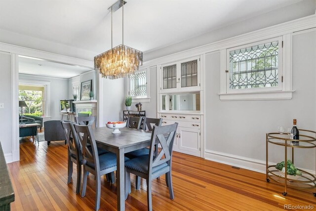 dining room featuring baseboards, an inviting chandelier, and hardwood / wood-style floors