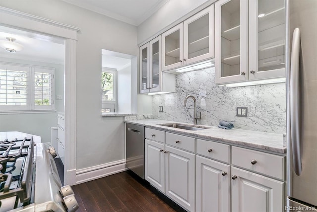 kitchen with white cabinets, appliances with stainless steel finishes, a sink, decorative backsplash, and dark wood-style floors