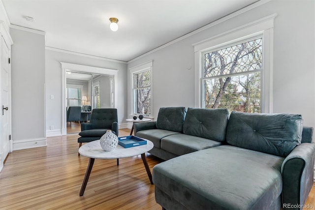 living room with light wood-style floors, baseboards, and crown molding