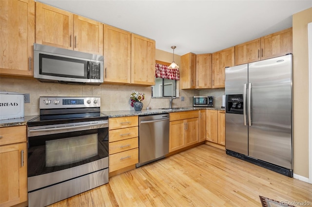 2871 Humboldt Cir, Longmont, CO 80503 - kitchen with stainless steel appliances, light wood-type flooring, decorative backsplash, and dark stone countertops