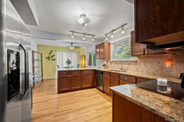 8060 Meadowdale Sq, Niwot, CO 80503 - kitchen with stainless steel appliances, a peninsula, light wood finished floors, and backsplash