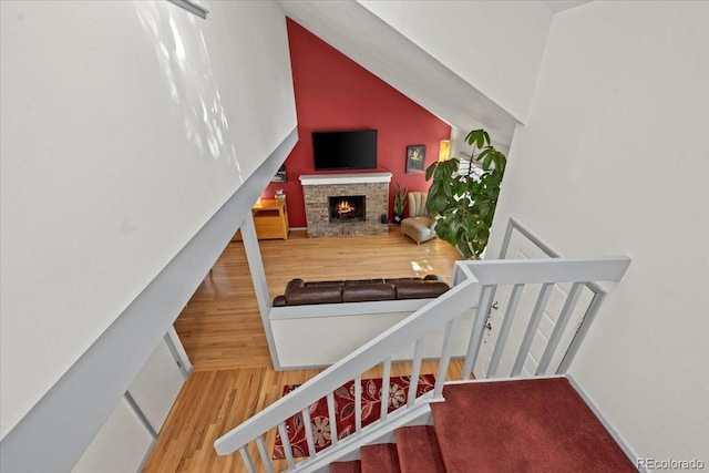 8060 Meadowdale Sq, Niwot, CO 80503 - staircase with wood finished floors, a warm lit fireplace, and vaulted ceiling