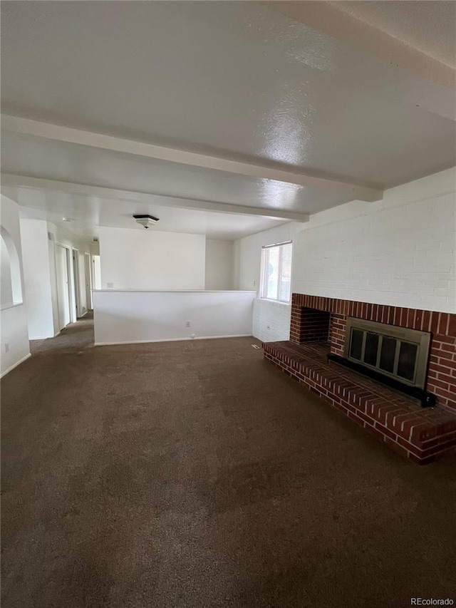 unfurnished living room featuring beam ceiling, carpet, and a fireplace