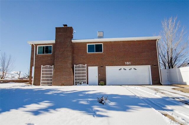 view of snowy exterior featuring a garage