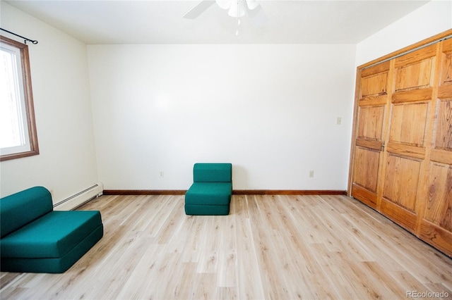 unfurnished room featuring a baseboard heating unit, ceiling fan, plenty of natural light, and light hardwood / wood-style flooring