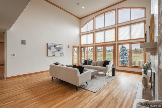 living room with crown molding, high vaulted ceiling, light wood finished floors, and baseboards