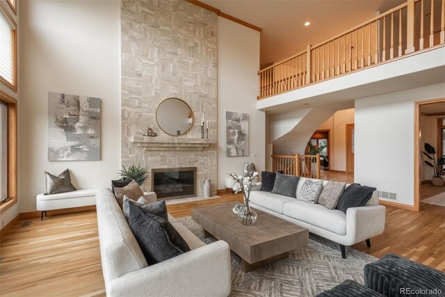 101 Glenmoor Ln, Cherry Hills Village, CO 80113 - living area featuring a towering ceiling, a stone fireplace, wood finished floors, and recessed lighting