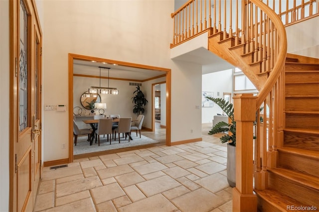 101 Glenmoor Ln, Cherry Hills Village, CO 80113 - foyer entrance featuring a high ceiling, stairway, stone tile floors, and ornamental molding