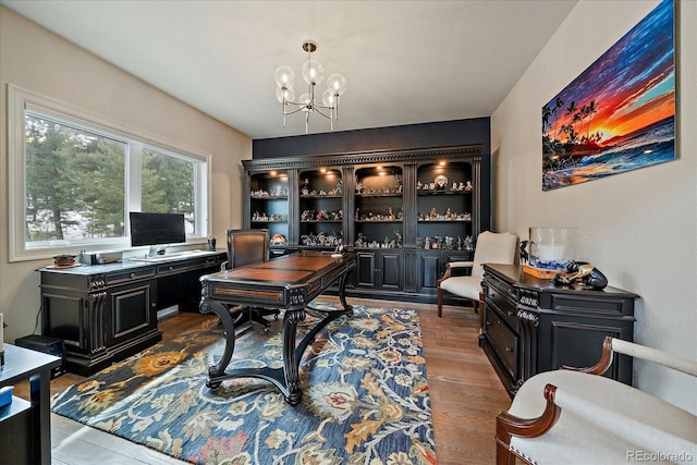 office area featuring an inviting chandelier and wood finished floors