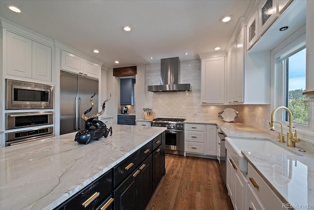 kitchen featuring white cabinetry, ventilation hood, dark wood-style flooring, and built in appliances