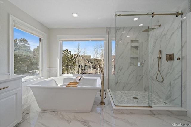 full bathroom featuring a freestanding tub, a marble finish shower, marble finish floor, and recessed lighting