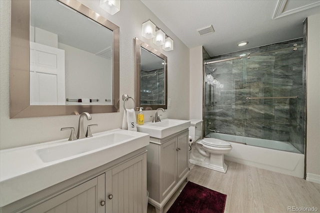 bathroom featuring two vanities, wood finished floors, visible vents, and a sink