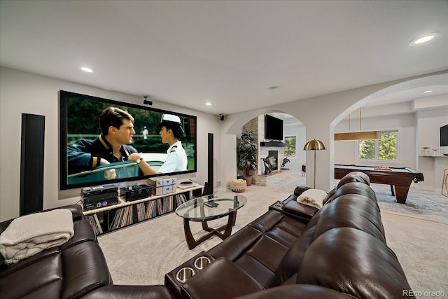 carpeted cinema room with a stone fireplace, billiards, recessed lighting, and arched walkways