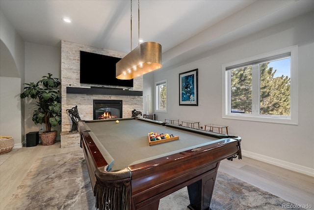 rec room featuring a fireplace, baseboards, and light wood-style floors