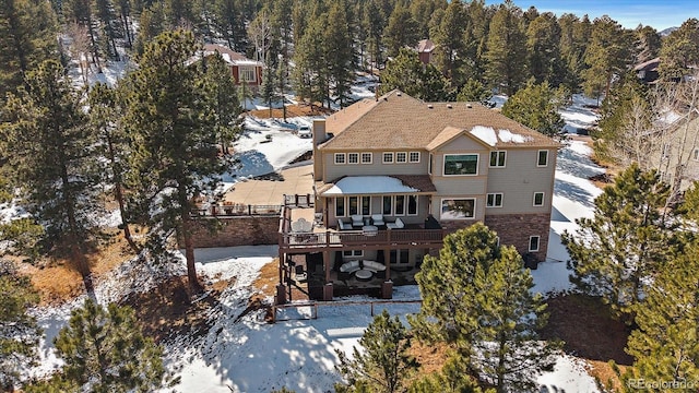 snowy aerial view featuring a view of trees