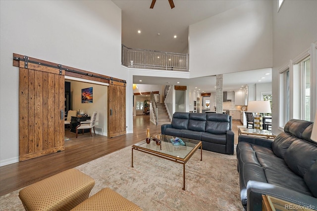 1366 Killington Ct, Evergreen, CO 80439 - living room with a towering ceiling, a barn door, stairway, wood finished floors, and baseboards