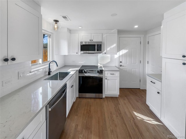 kitchen featuring a sink, stainless steel appliances, dark wood-style floors, and white cabinetry