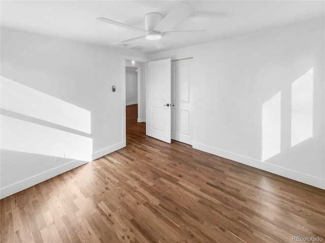 spare room with wood finished floors, baseboards, and ceiling fan