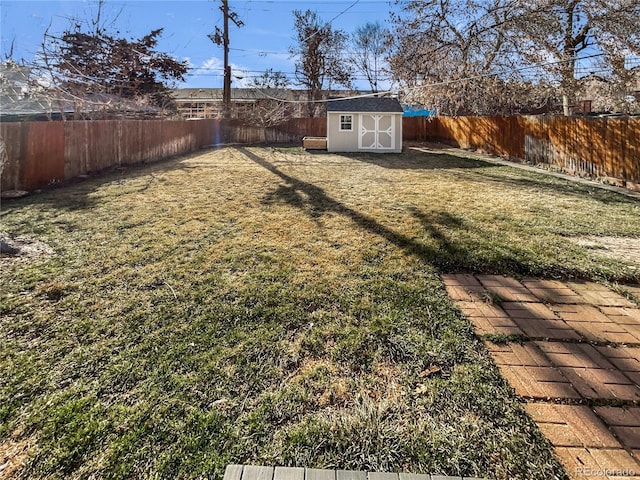 view of yard with a fenced backyard, a storage unit, and an outdoor structure