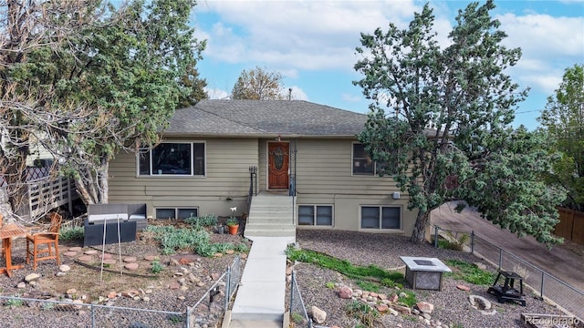 view of front of house with fence and roof with shingles