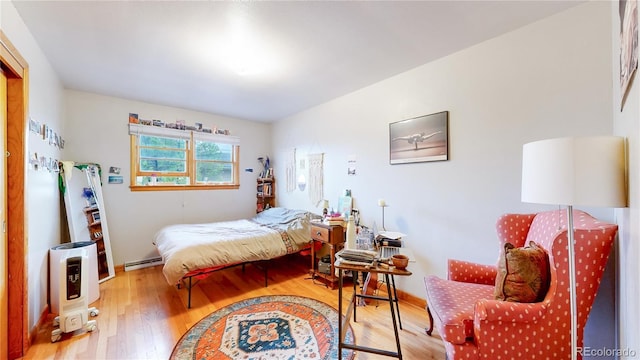 bedroom featuring a baseboard radiator and wood finished floors