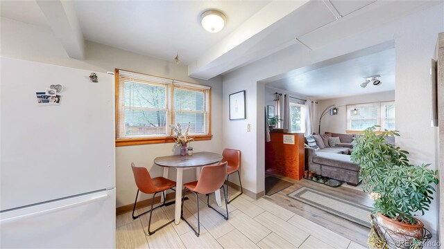 dining space with baseboards and beam ceiling