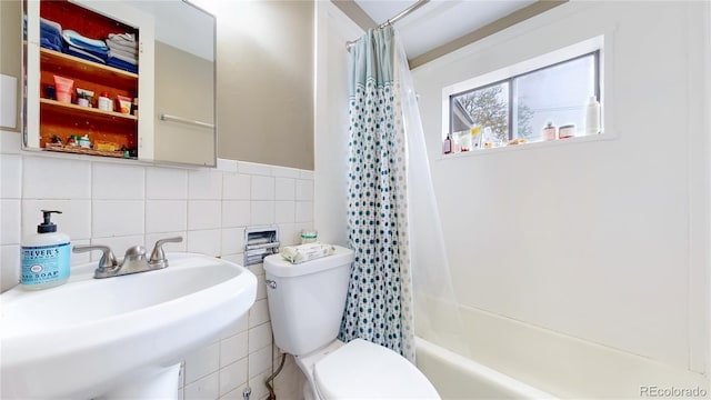 full bathroom featuring a sink, toilet, shower / bath combo with shower curtain, tile walls, and backsplash