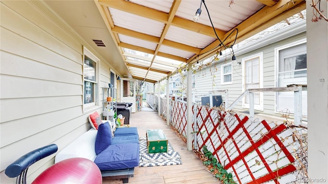 wooden deck featuring outdoor lounge area and visible vents