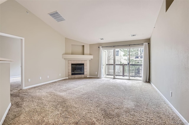 unfurnished living room with high vaulted ceiling, a tiled fireplace, and carpet flooring