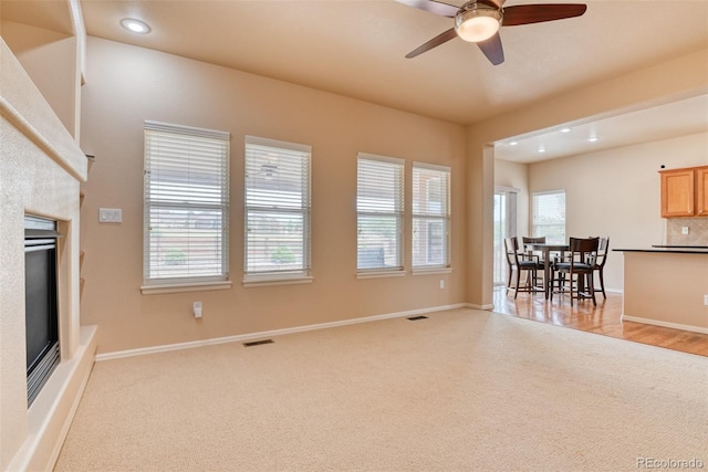 carpeted living room with ceiling fan