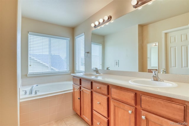 bathroom with tile patterned flooring, vanity, and a relaxing tiled tub