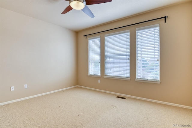 carpeted spare room with ceiling fan