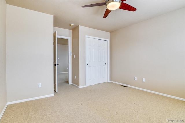 unfurnished bedroom featuring ceiling fan, carpet, and a closet