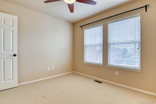 carpeted spare room featuring ceiling fan