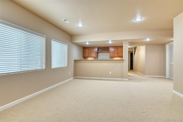 unfurnished living room featuring indoor bar and light carpet